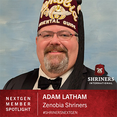 Shriners  International  Logo;  NEXTGEN  MITGLIED  IM  FOKUS;  ADAM  LATHAM;  Zenobia  Shriners;  #SHRINERSNEXTGEN;  Ein  Mann  im  Anzug  mit  Krawatte  und  einem  Fes  mit  der  Aufschrift  