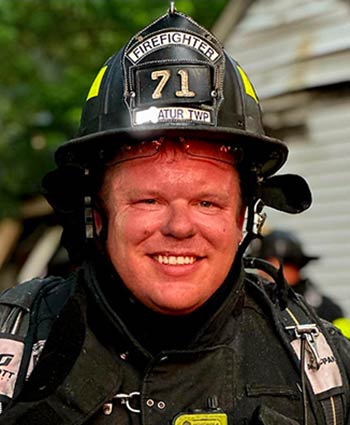 Chris Smallwood wearing firefighter gear
