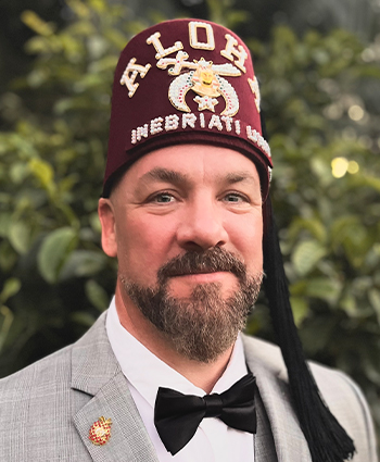an adult man wearing a suit and a fez