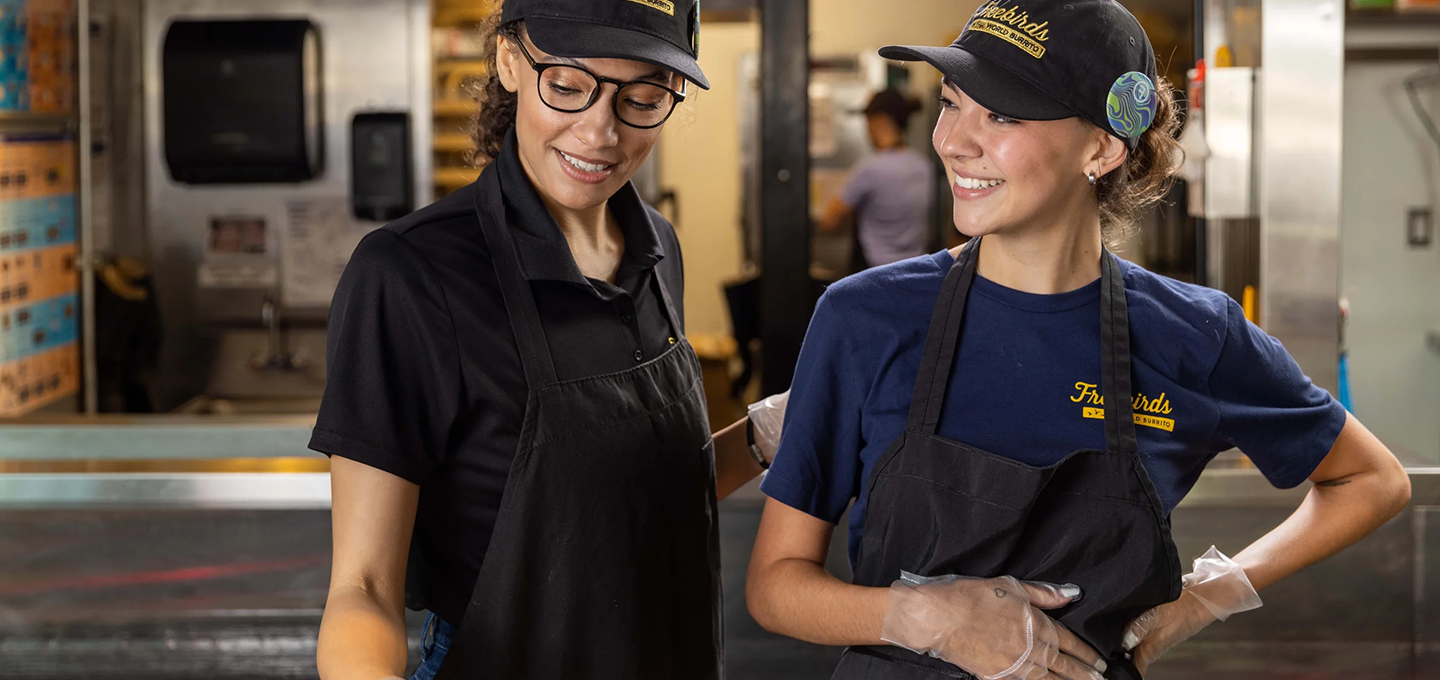two freebird workers smiling and talking