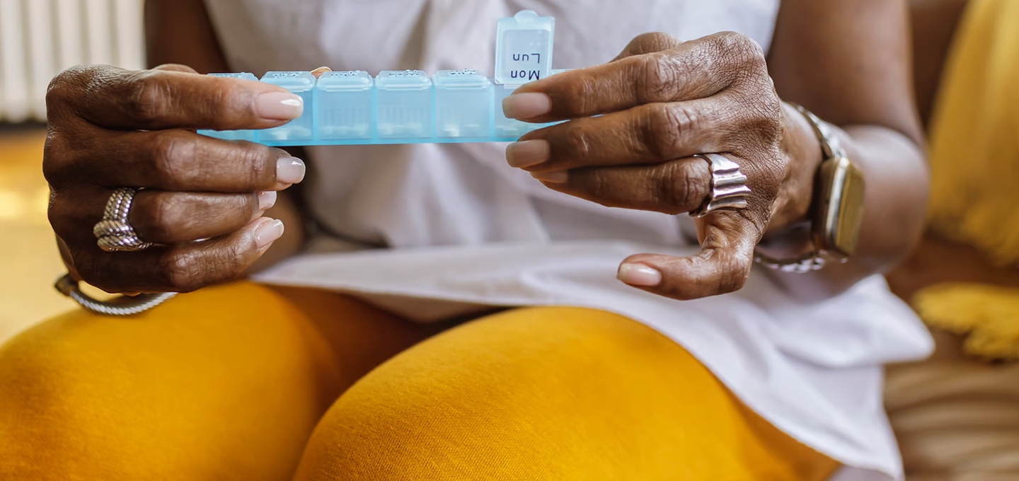 hands holding weekly vitamin dispenser