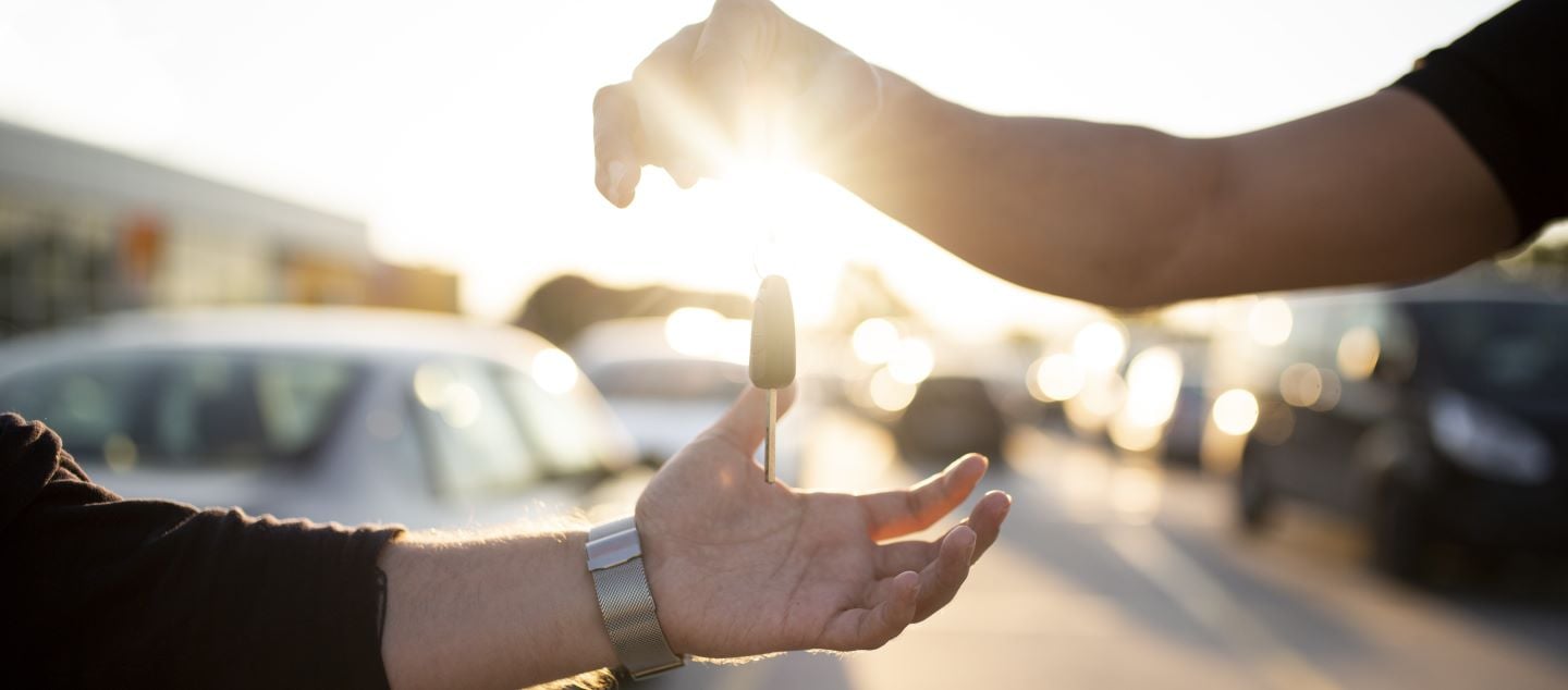 Hands passing a car key