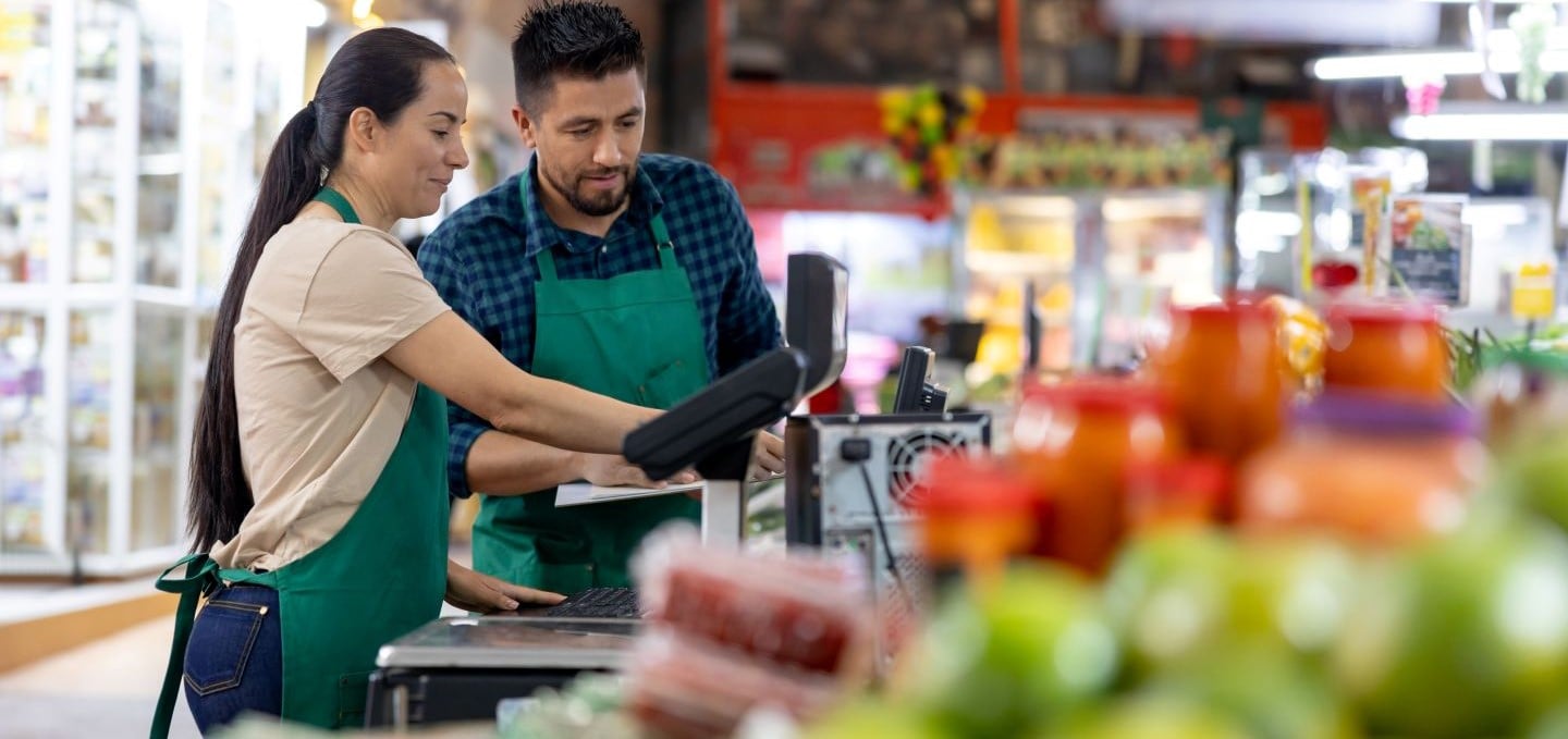 Two frontline staff training at a grocery store