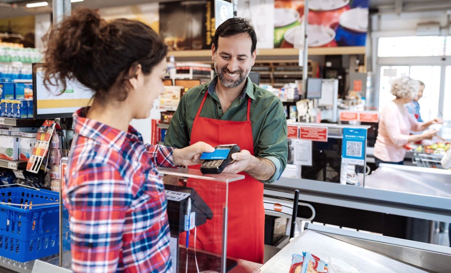 Grocery Store clerk helping a customer pay