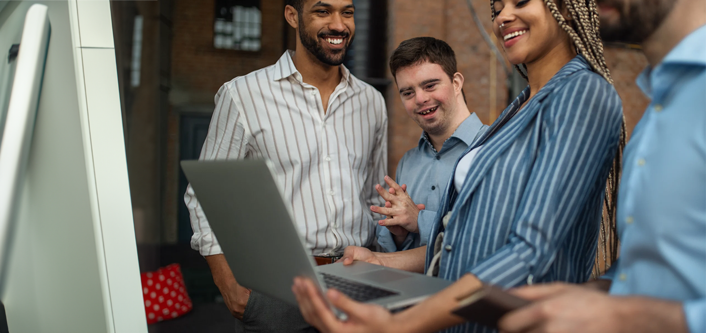 people smiling, talking and looking at computer