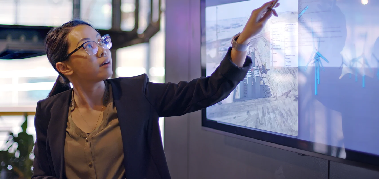 presenter gesturing toward on screen info