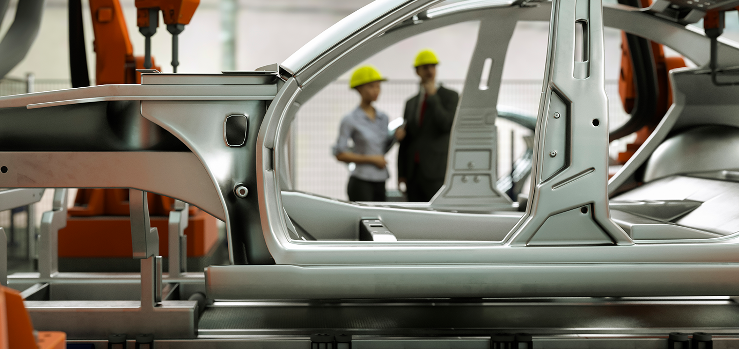 shot of two people through the frame of a car being built