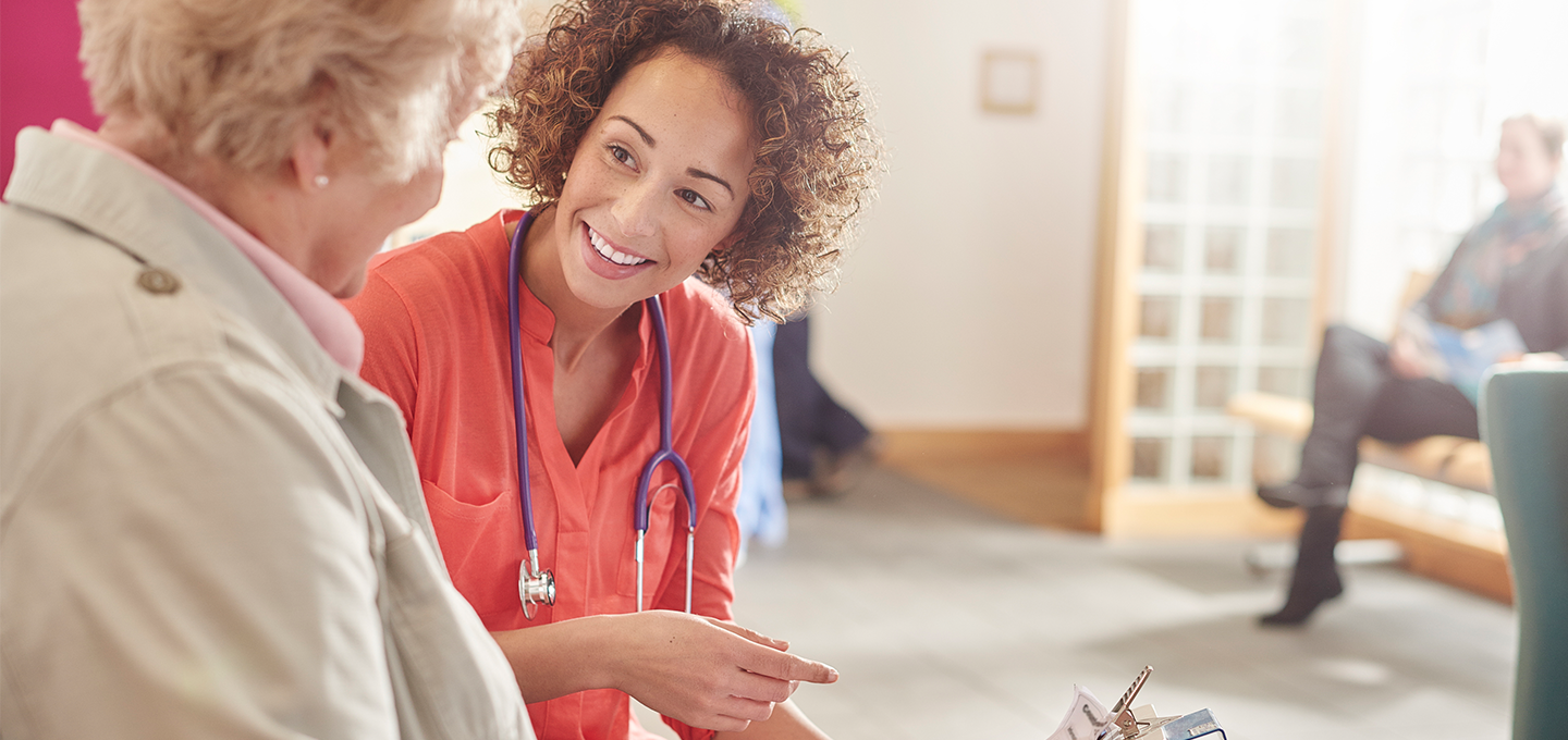 doctor or nurse talking with elderly patient