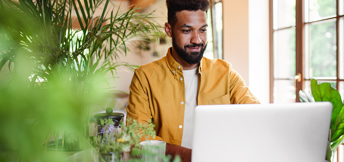 man working at desk with plants around