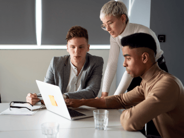 Three people looking at a laptop
