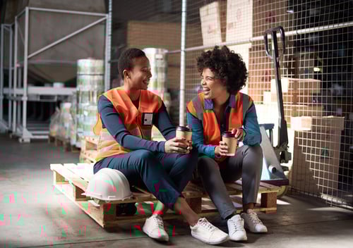 Two women drinking coffee on a work break.