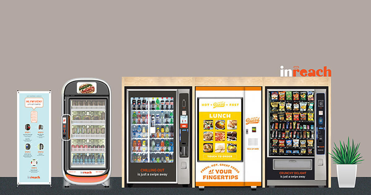 Row of vending machines offering drinks, snacks, and hot meals, with an informational banner on the left and a potted plant on the right against a neutral wall.