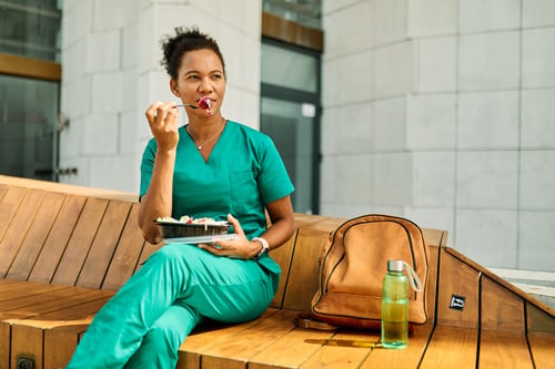 A healthcare worker eating a salad.