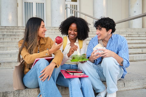 A group of students eating lunch on steps.