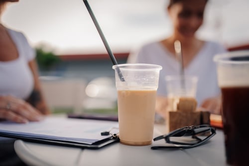 Cups of iced coffee on a table during a casual meeting.