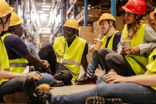 Warehouse workers sitting and eating on their lunch break.