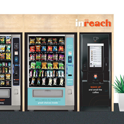 Row of vending machines offering drinks, snacks, wellness items, and coffee under an inReach display.