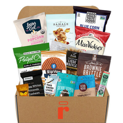 Open box filled with assorted snacks, including popcorn, chips, granola, cookies, and bars.