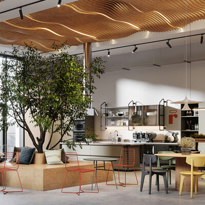 Modern office lounge with a large indoor tree, cozy seating, and an open kitchen area with natural light.