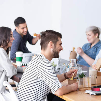 People sitting together at a table enjoying food and drinks in a casual group setting.