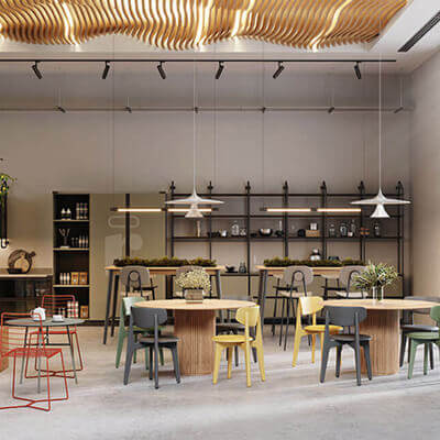 Modern café-style office space with wooden tables, colorful chairs, pendant lights, and a back wall featuring shelves with plants and decorative items under a wavy ceiling design.