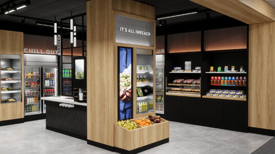 Modern micro-market with wooden accents, shelves of snacks, drinks, and fresh produce display.