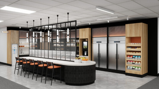Modern pantry area with a long counter, bar stools, shelves of snacks, and stainless steel refrigerators.
