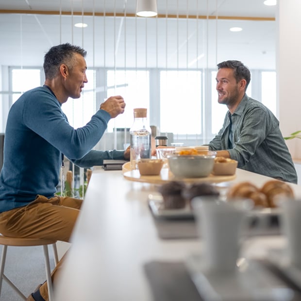 2 men enjoying a snack in a break room