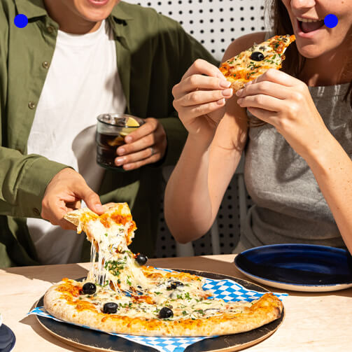 people eating pizza black olives blue plates