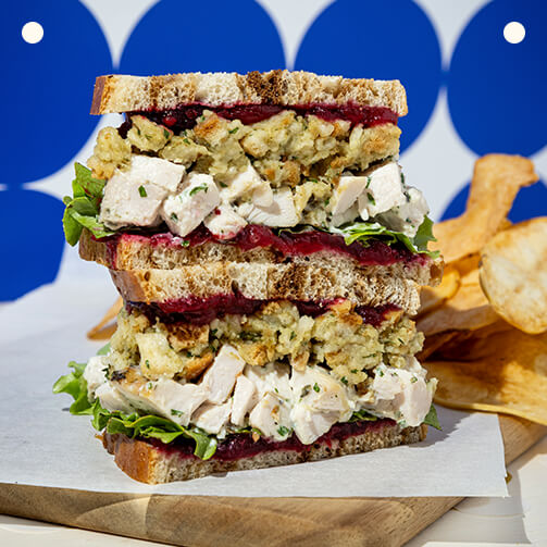 A freshly made sandwich placed on a rustic wooden board