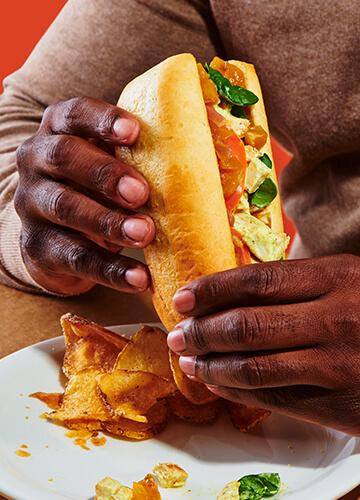 A man is holding a sandwich showcasing a delicious meal ready to be enjoyed