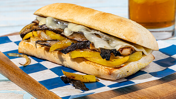 A sandwich placed on a wooden cutting board, showcasing its layers and ingredients.