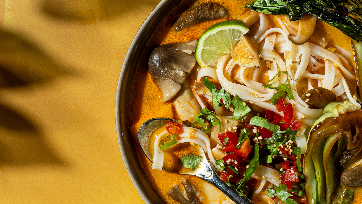 Tom kha soup with rice noodles, straw mushrooms, bamboo shoots, and sesame-roasted bok choy