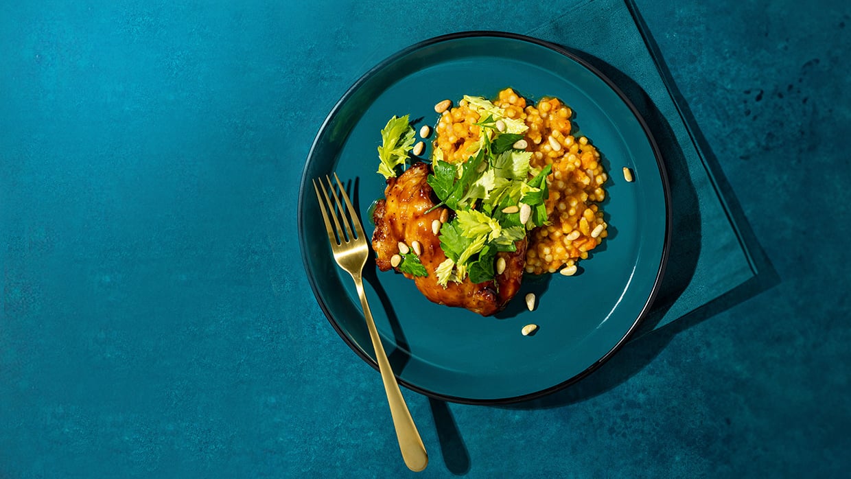 Orange-honey glazed chicken thighs with carrot couscous and pine nuts