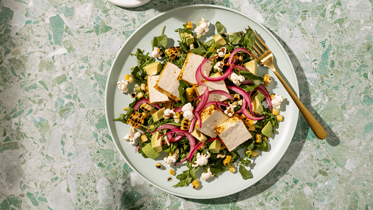 Seared tofu, charred corn, avocado, and pickled onion with celery salt popcorn.