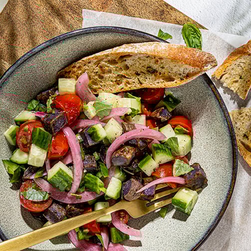 A plate of food featuring a slice of bread and a fork placed beside it.