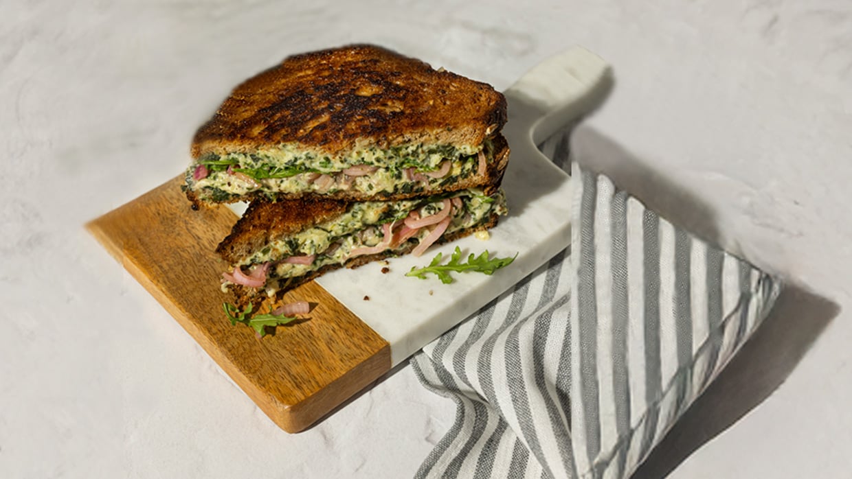 brie spinach artichoke melt on a wooden chopping board