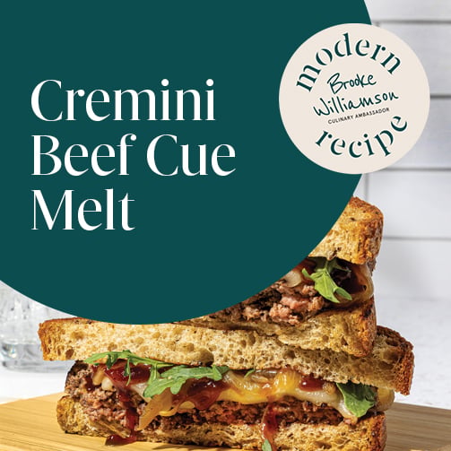 Graphic reading “Cremini Beef Cue Melt” over stacked beef melt sandwich with cheese, onions, and greens