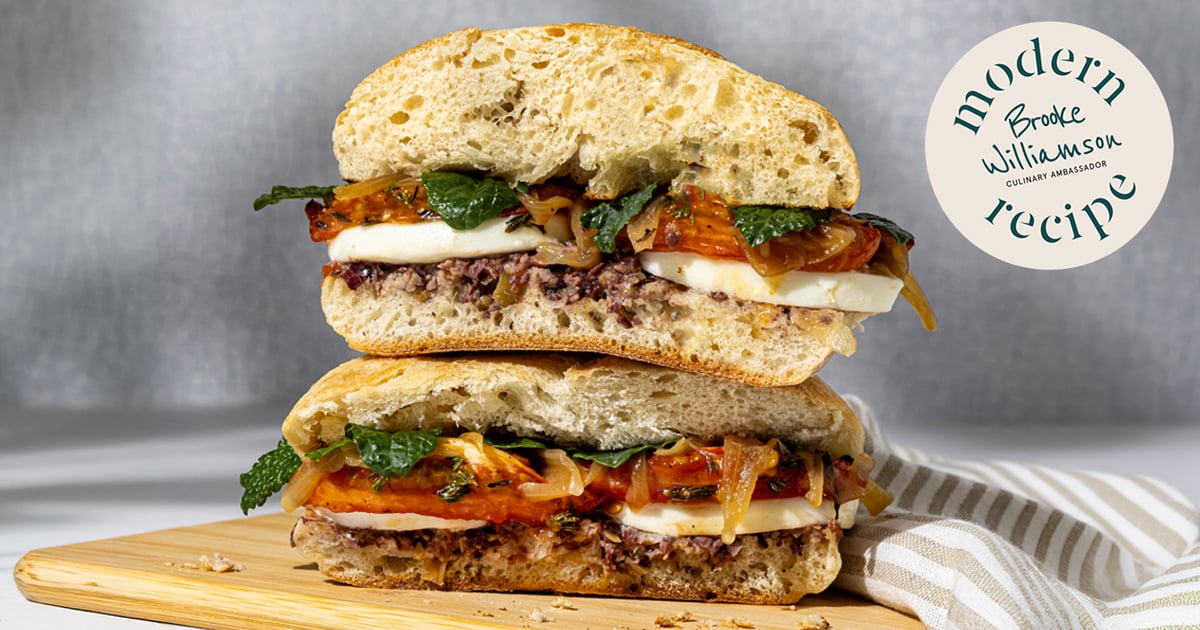 Two stacked Mediterranean beef caprese sandwiches with mozzarella, tomatoes, caramelized onions, and herbs.