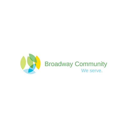 Logo for 'Broadway Community' featuring a circular design with overlapping leaf shapes in green, yellow, and blue, accompanied by the text 'Broadway Community' in green and the tagline 'We serve.' in blue, symbolizing growth and community service