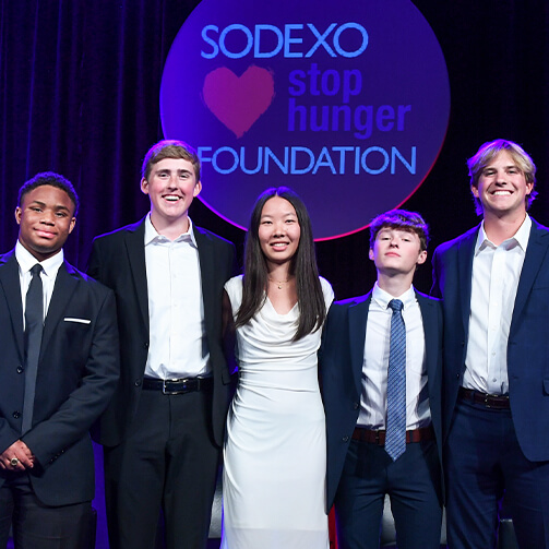 A group of smiling individuals holding awards at a charity event, celebrating their achievements and contributions.