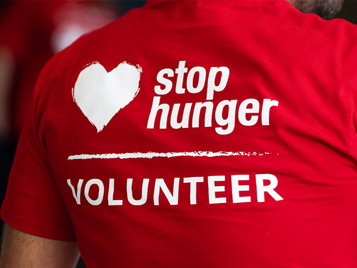 person with a red stop hunger volunteer t-shirt