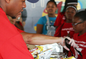 people serving some food to a group of women