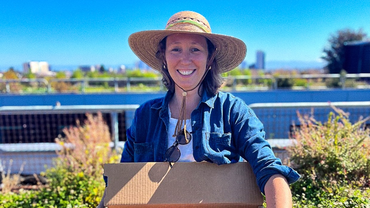female farmer holding box of produce