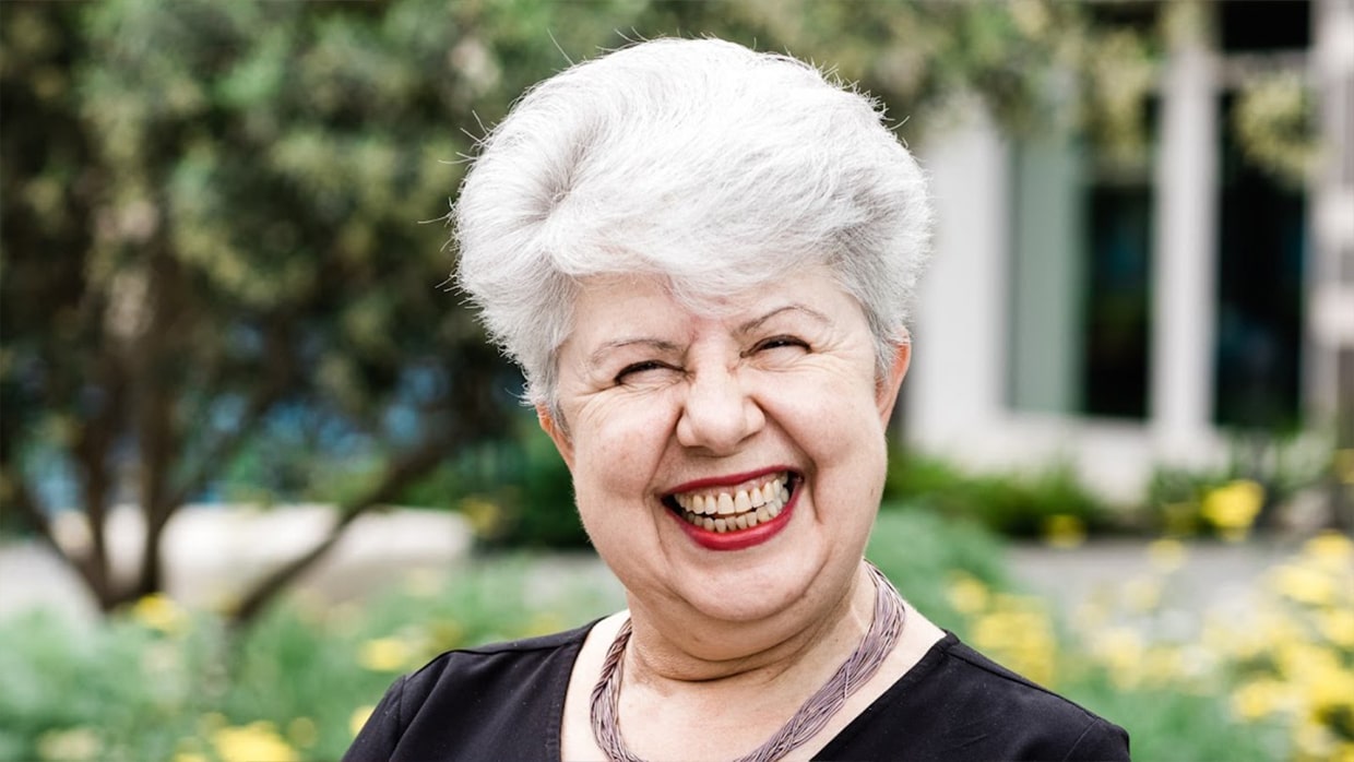 woman standing near a garden with a big smile