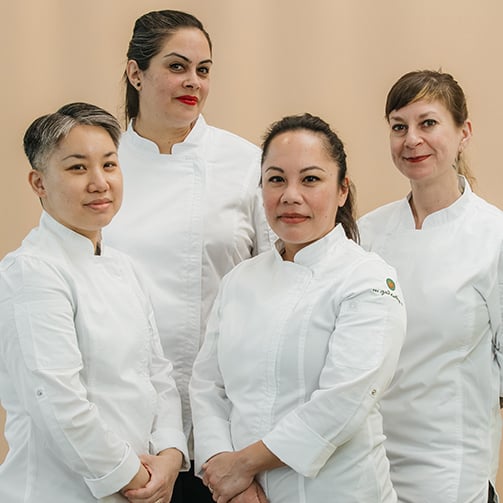 A dedicated hotel kitchen team collaborates to prepare meals, showcasing teamwork and culinary expertise in a vibrant setting.