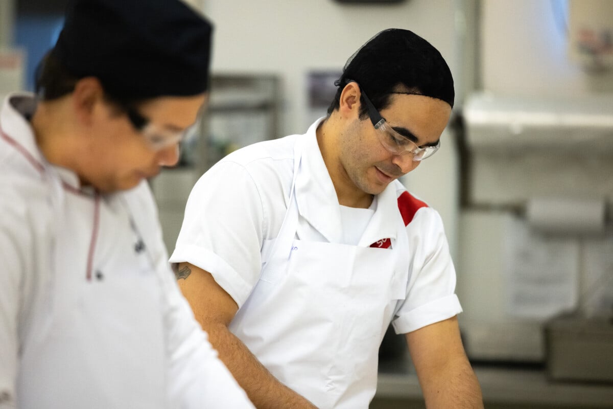 Dois profissionais trabalham em uma cozinha industrial.(FOTO 1)