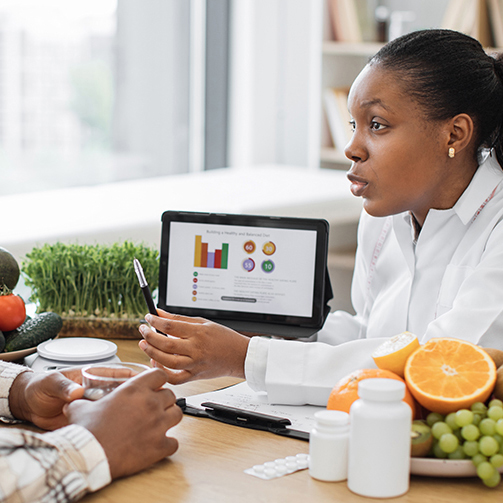 dietician reviewing data with fresh fruit next to her