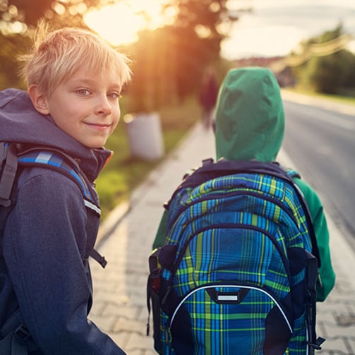 smiling boy walking with another boy