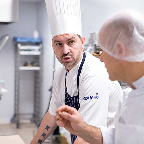 male chefs talking in kitchen